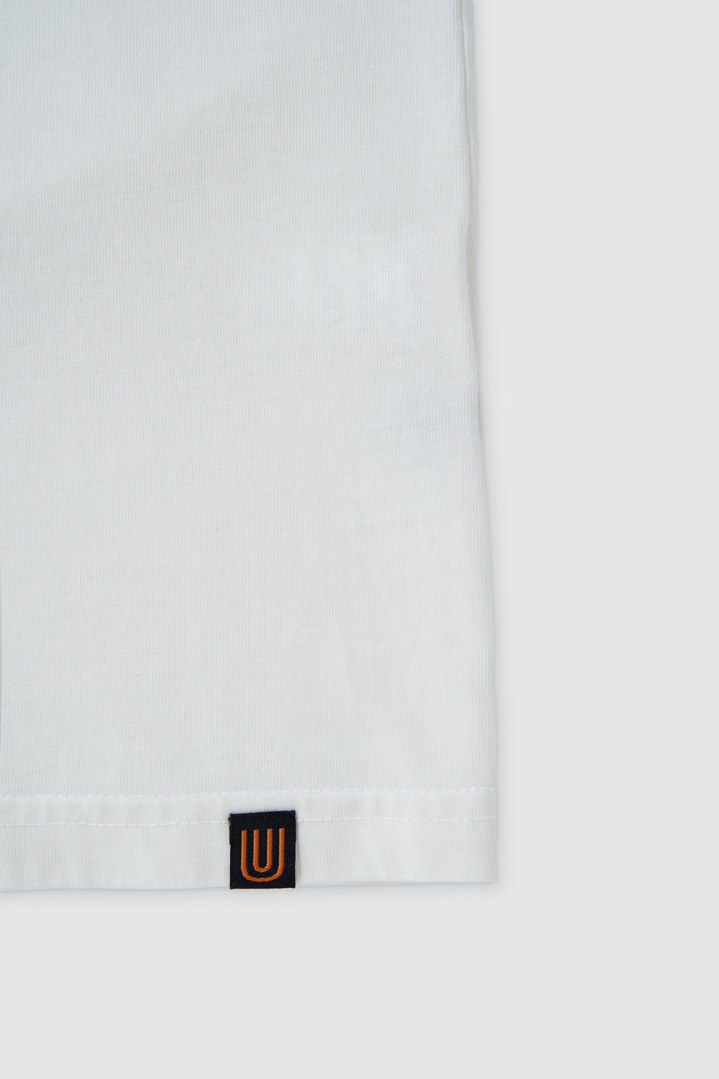 White hoodie with a small logo on the chest against a white background