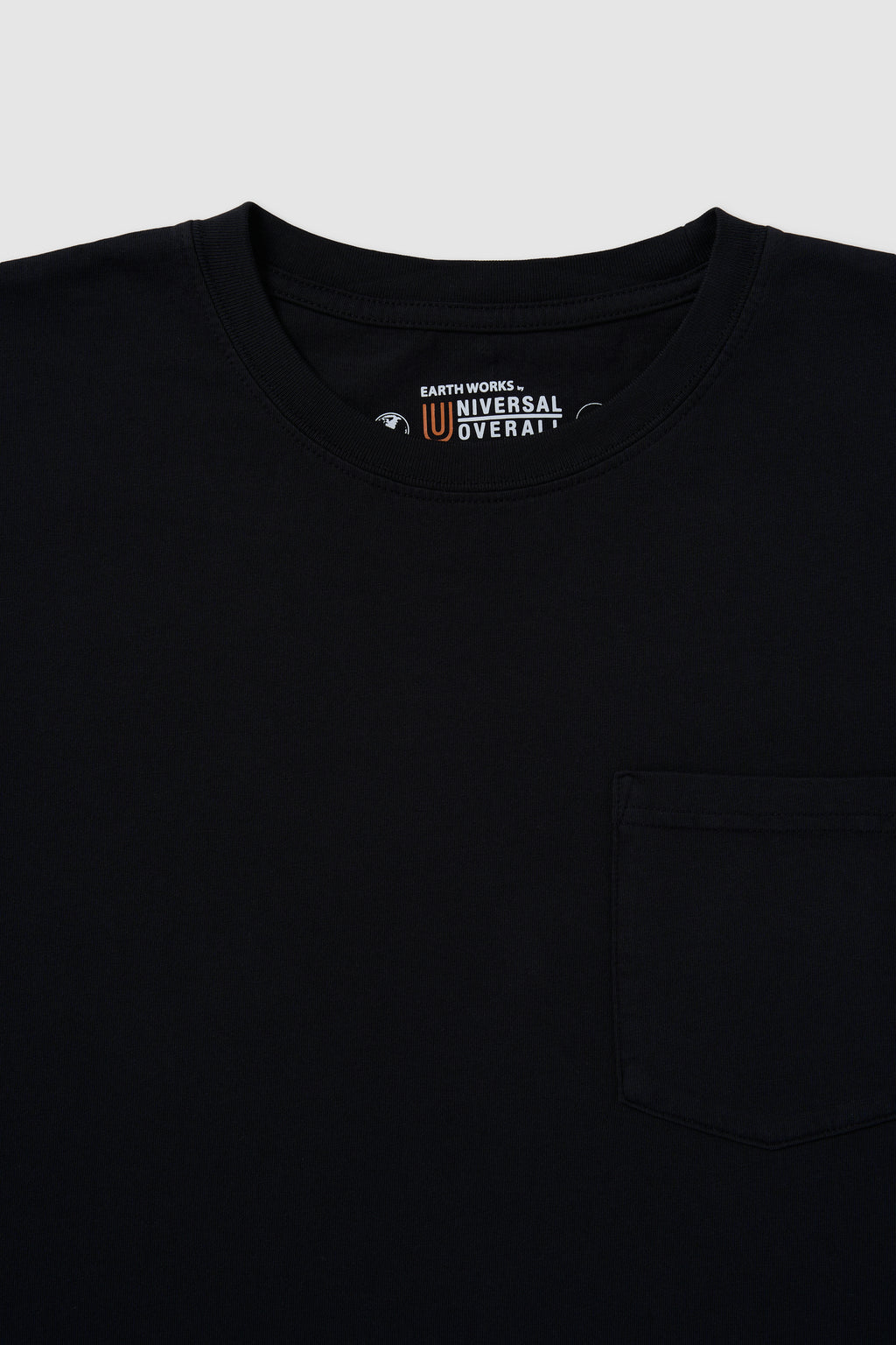 Black shirt with a visible brand logo on a light gray background