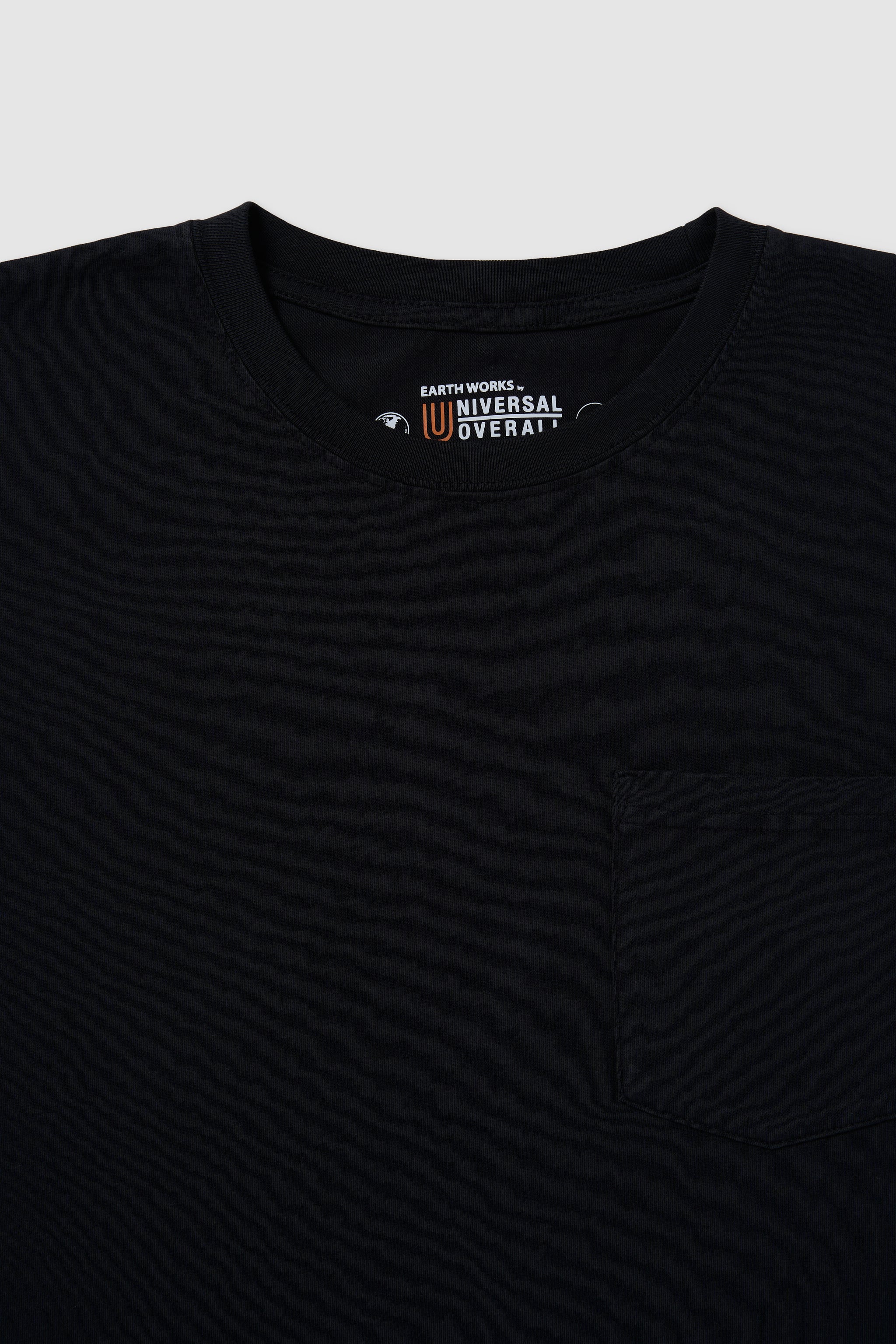 Black shirt with a visible brand logo on a light gray background