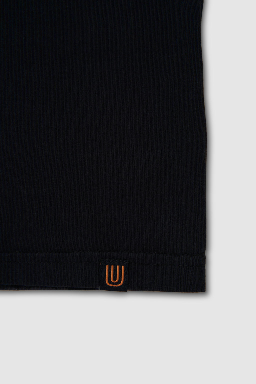 Black sleeve with a small orange logo on a white background