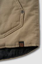 Close-up of a brown jacket with a button and brand logo on a white background