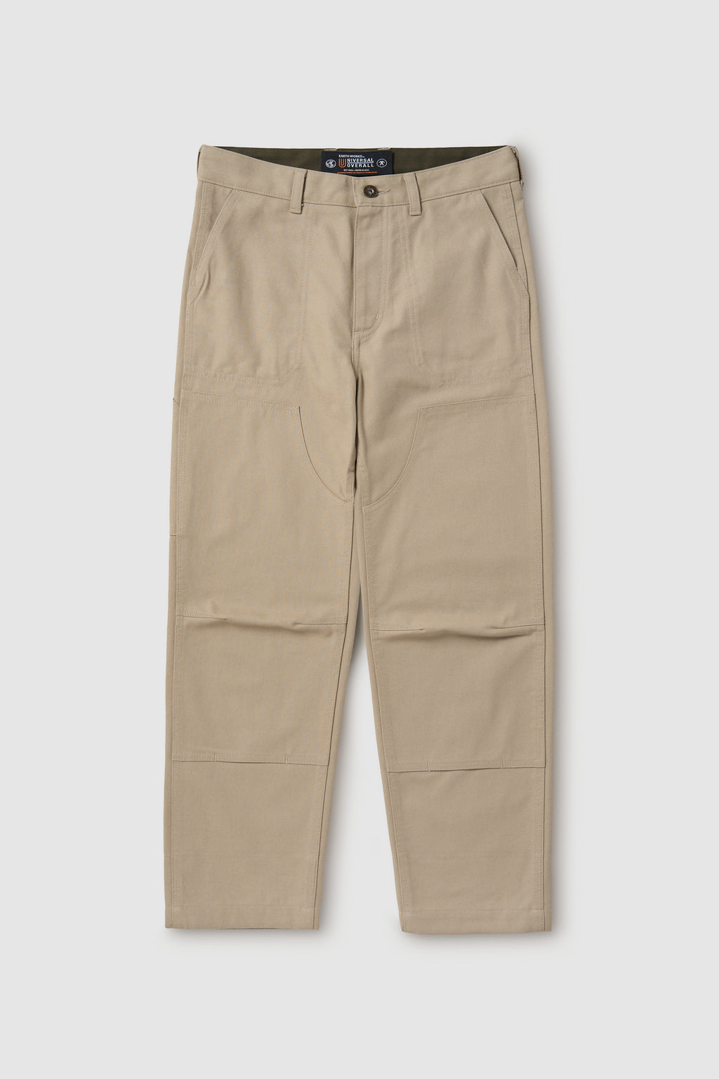 Beige pants with a visible brand label on a white background